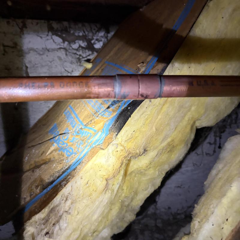 Copper plumbing pipe joint inside wall cavity with insulation