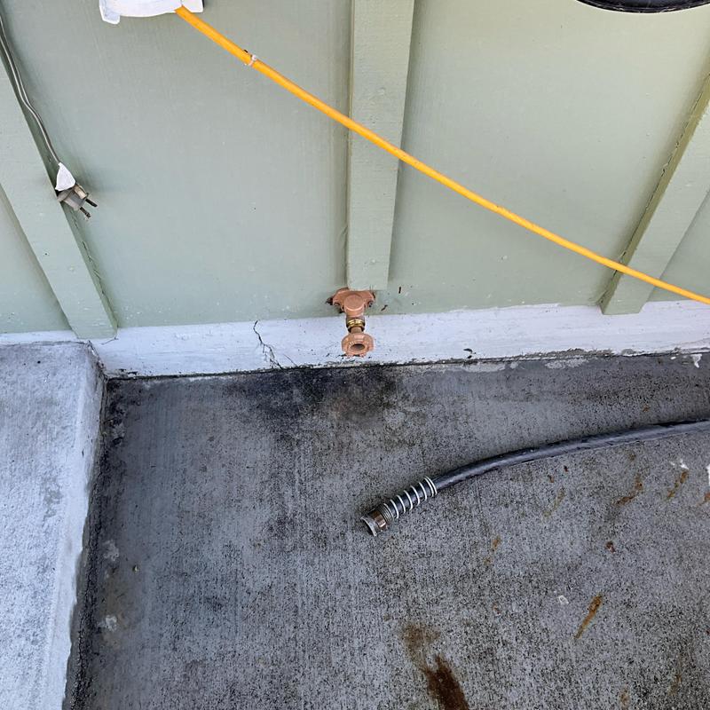 Outdoor hose bib replacement with attached hose coil on concrete