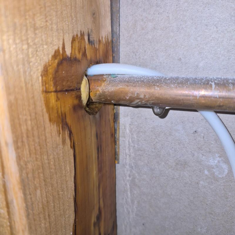 Copper water pipe with leak and wood damage Copper water pipe with leak and wood damage