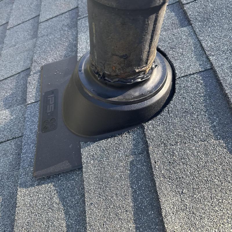 Pipe boot with new flashing on asphalt shingle roof
