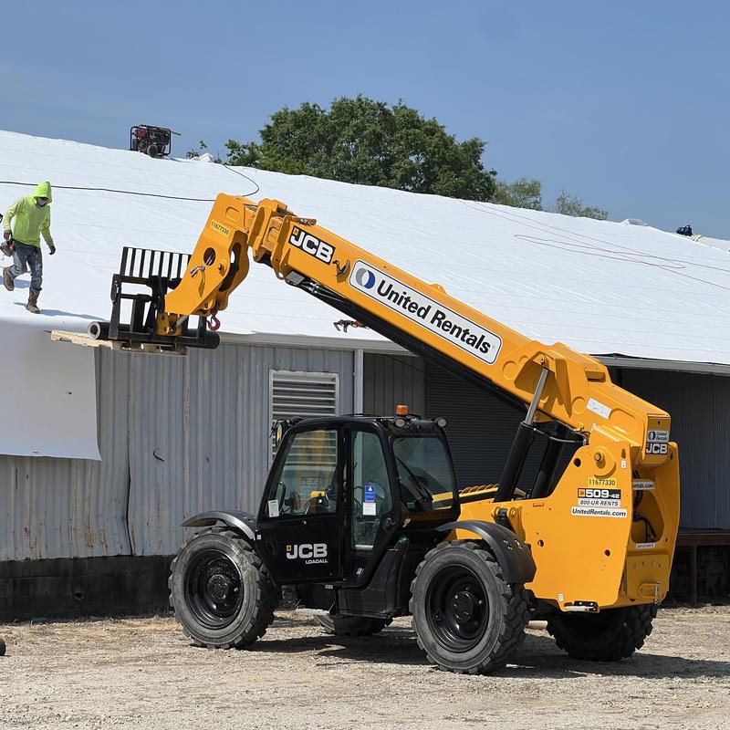 Versico TPO roofing membrane installation with telehandler