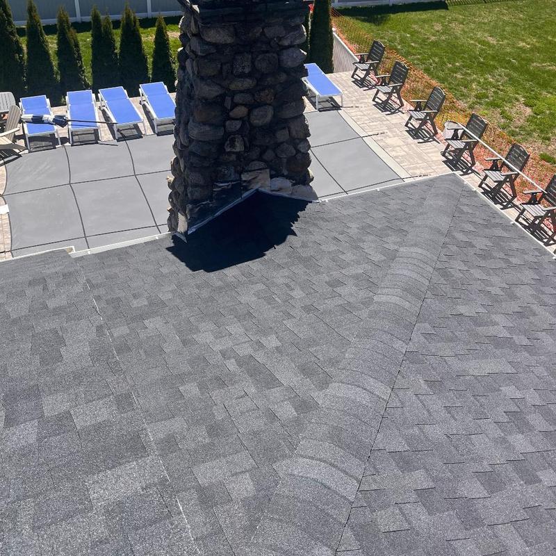 Asphalt shingle roof around stone chimney