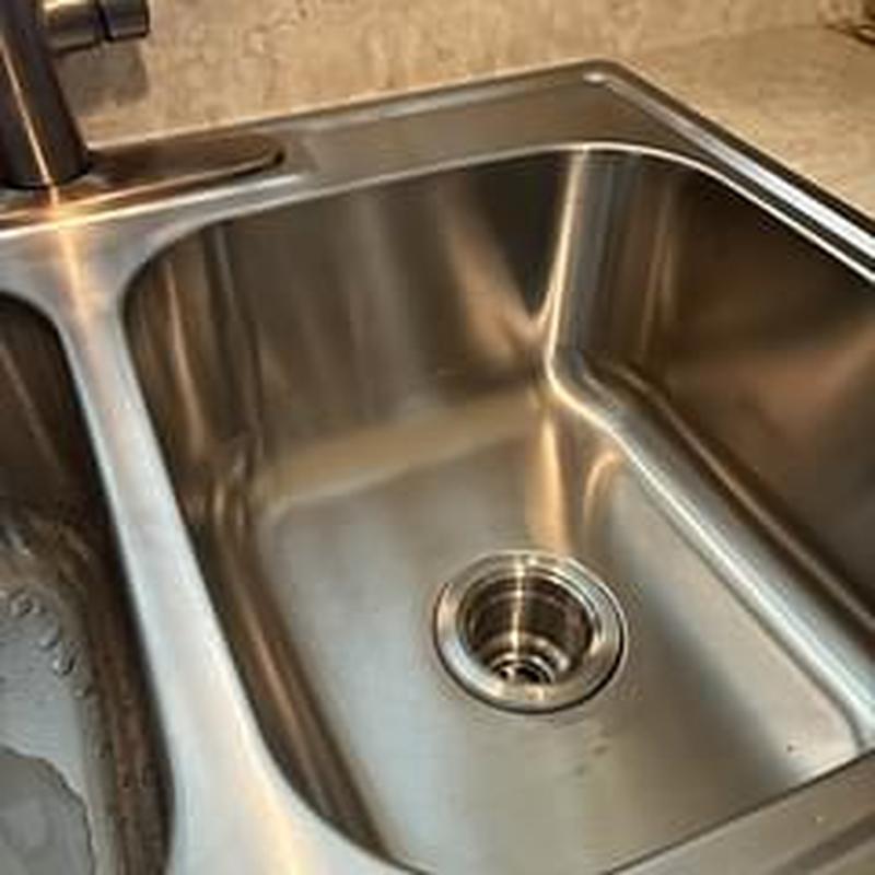 Stainless steel kitchen sink with basket strainer installed