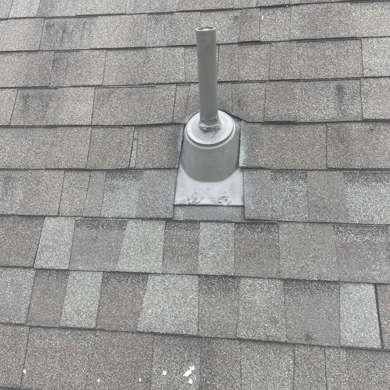 Pipe boot and vent flashing on gray shingle roof