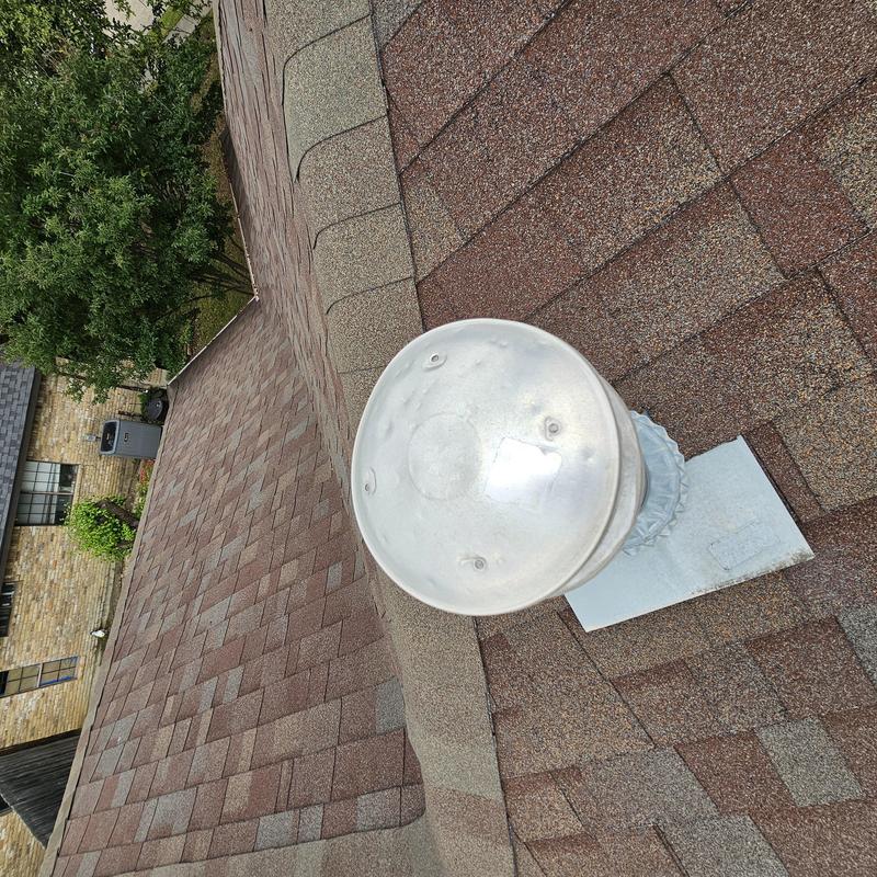 Roof vent cap with hail damage on asphalt shingles