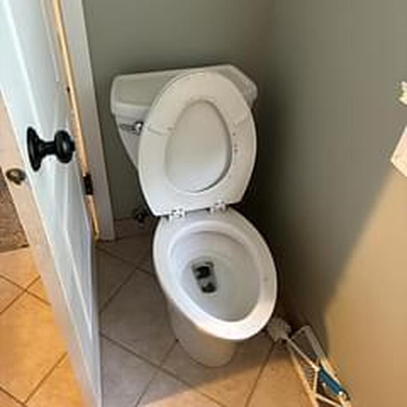 Toilet with raised seat in bathroom corner