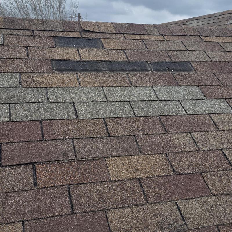 Asphalt shingle roof with damaged patch areas