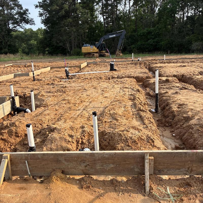 PVC plumbing pipes rough-in with excavator at site