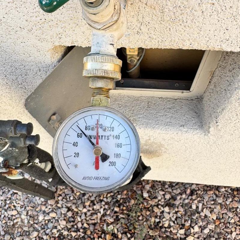 Pressure regulator valve gauge near water meter with rock ground