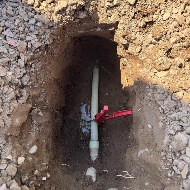 Water main with pressure reducing valve installation in dirt trench