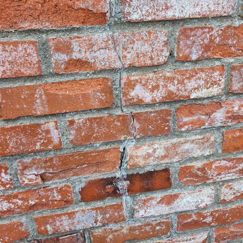 Brick chimney mortar with visible cracks and damage