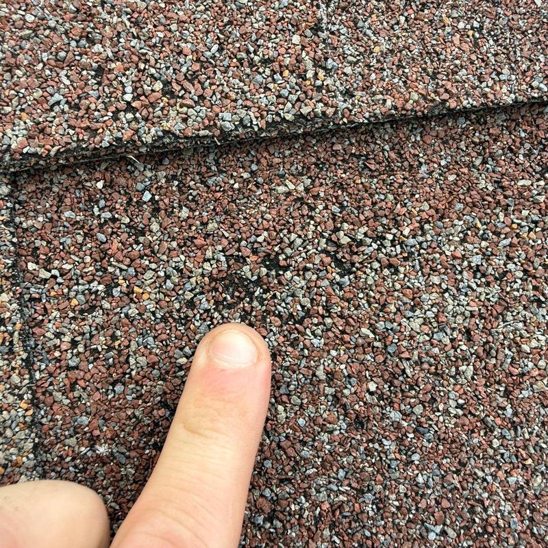 Roof shingles with hail damage near finger point