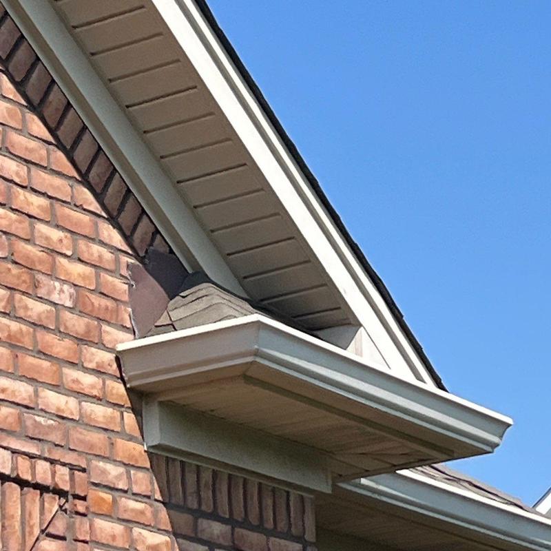 Roof shingles and flashing with hail damage near gutter