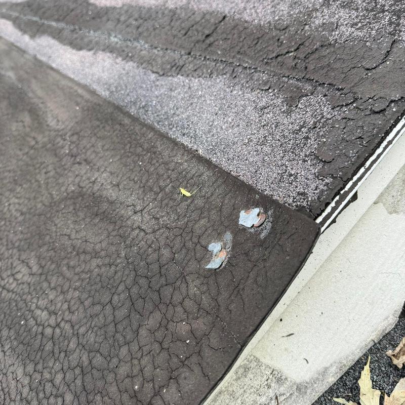 Asphalt shingle roof with hail damage and lifted nails