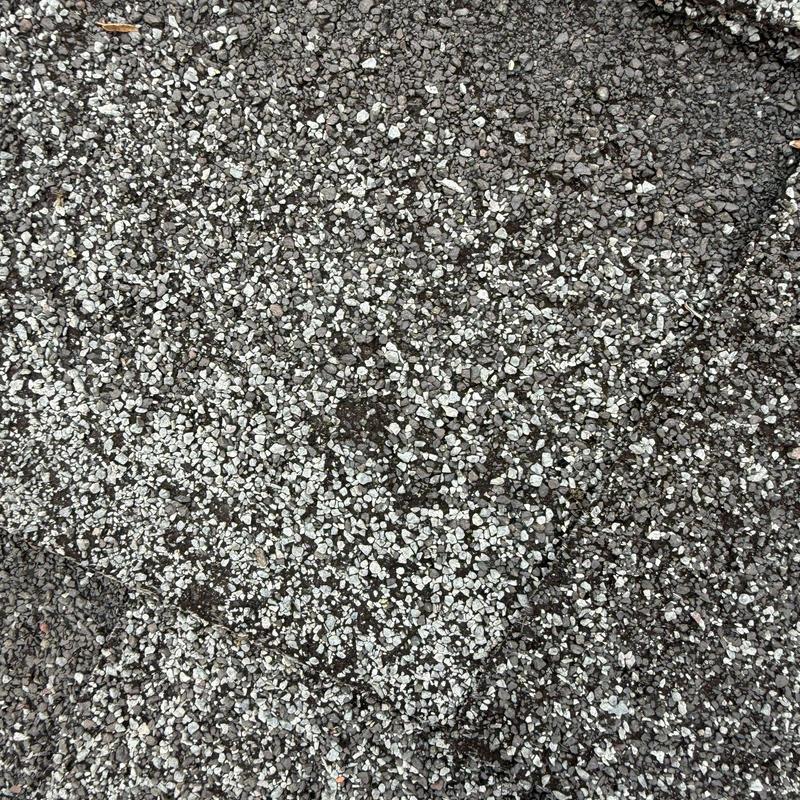 Asphalt roofing shingles with hail damage close-up