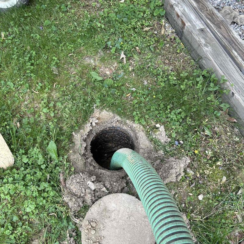 Septic tank opening with vacuum hose during pumping