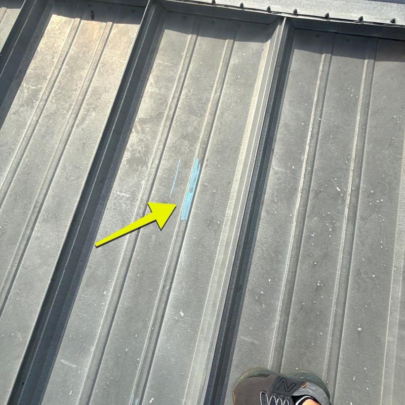 Metal roof panel with marked hail damage spot