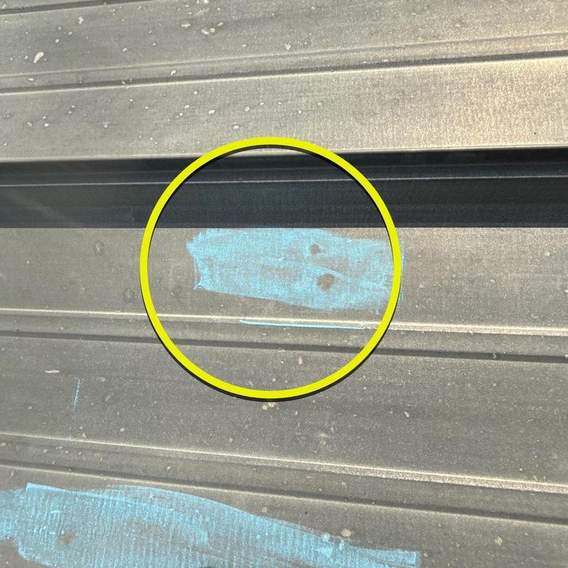 Metal commercial roofing panel with hail damage markings