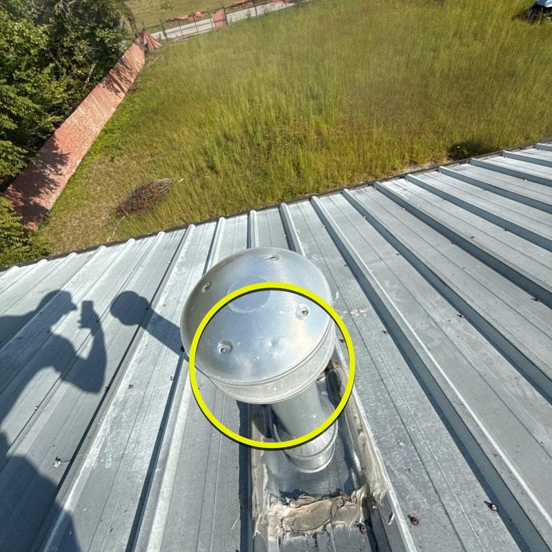 Metal roof vent with hail damage on commercial roof