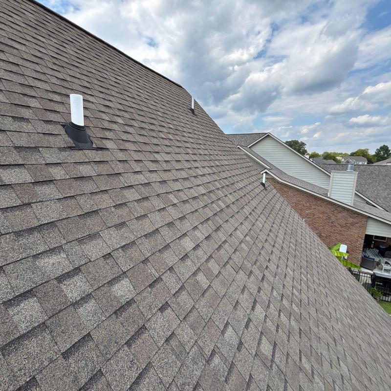 Asphalt shingle roof with vent pipe and nearby houses