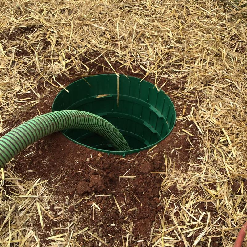 Septic tank riser with green pump hose