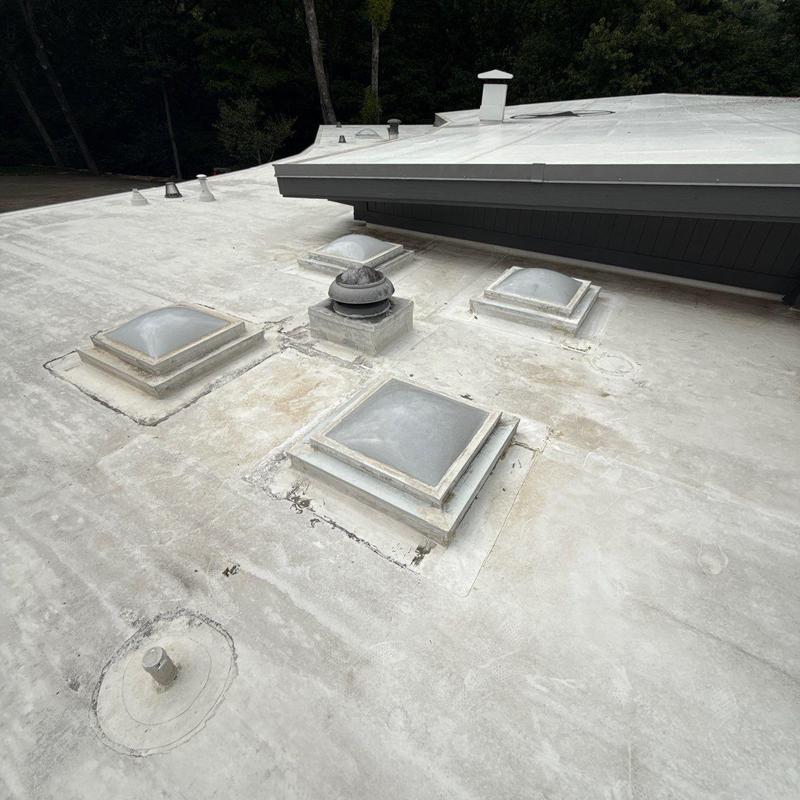 Flat roof skylights and vent flashings on white membrane roof