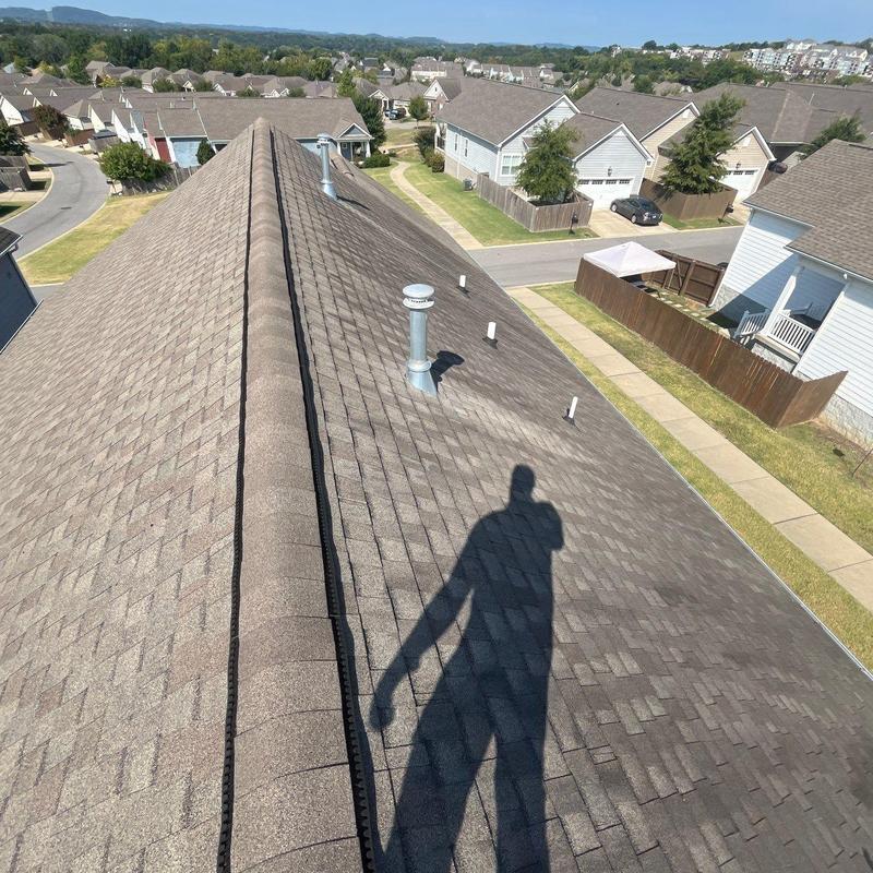 Asphalt shingle roof with ridge vent and plumbing vents