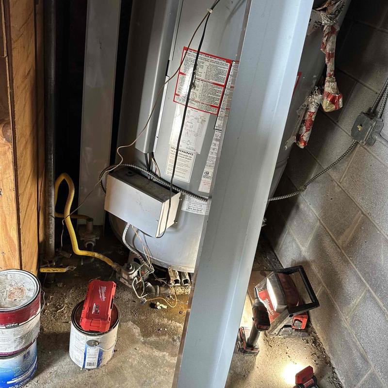 Water heater installation area with tools and wiring