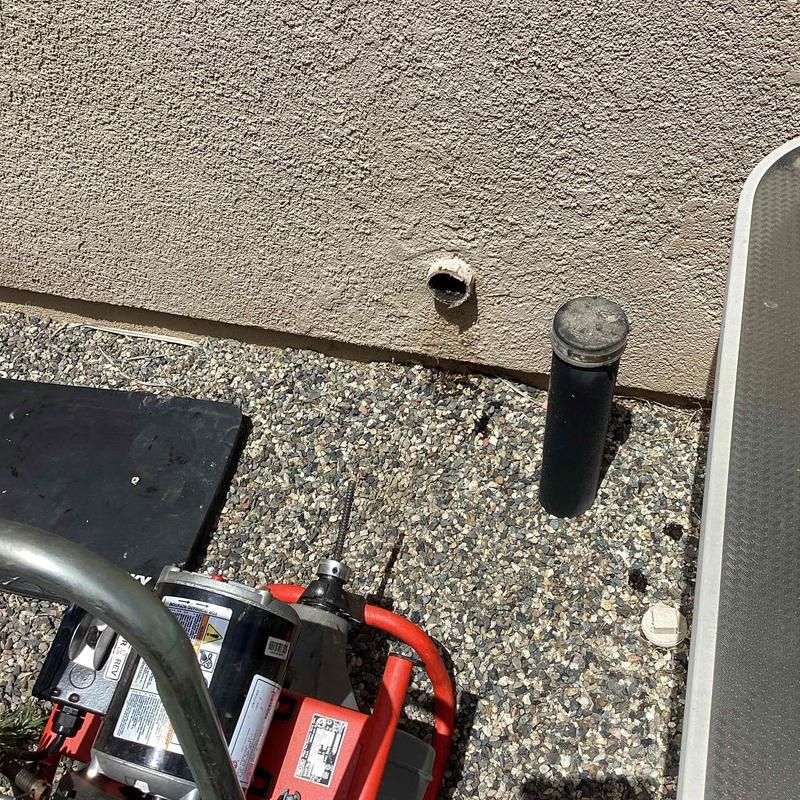 Outside cleanout with cable snake on gravel surface