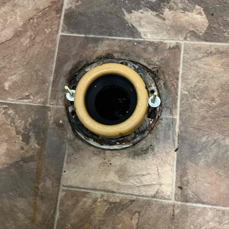 Closet flange with new wax seal on tiled floor