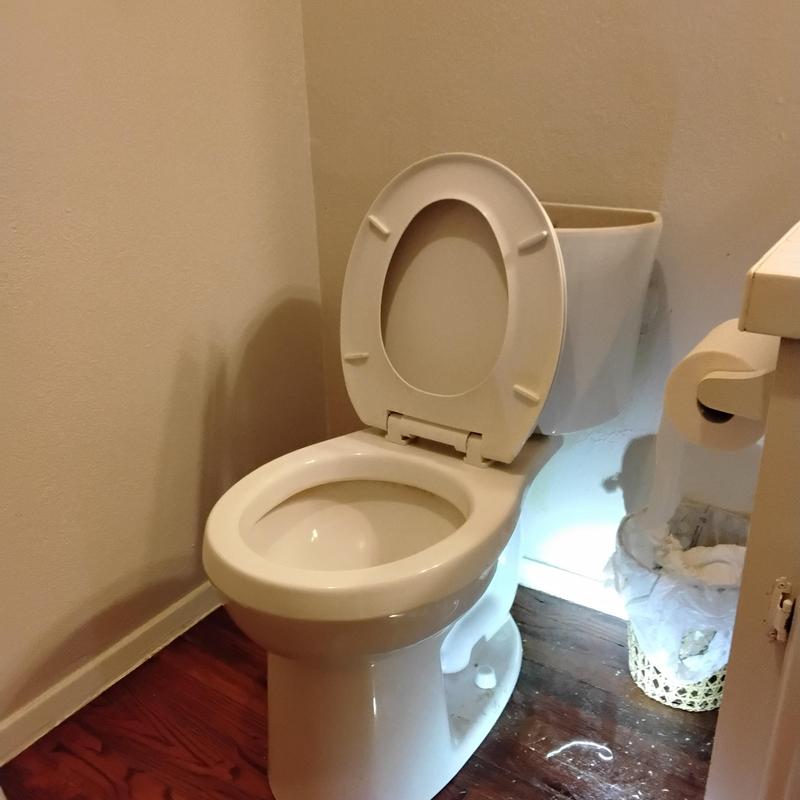 Toilet with open tank and seat in small bathroom