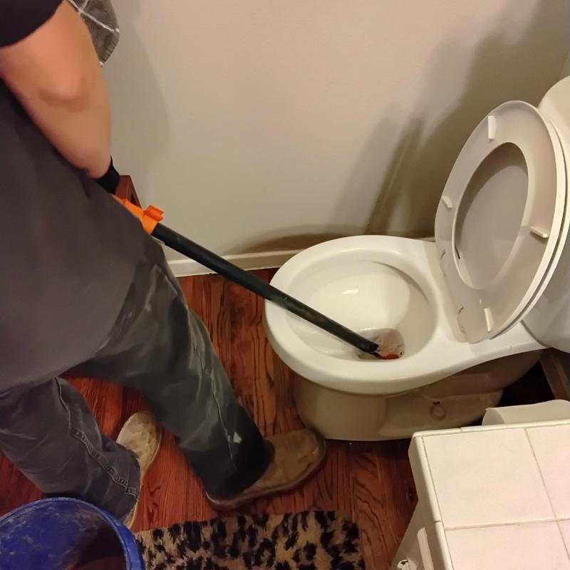 Toilet bowl blockage with plunger in bathroom