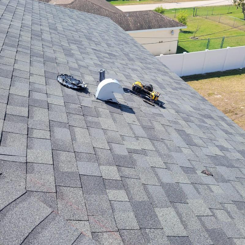 Shingle roof with repaired vent flashing and tools placed