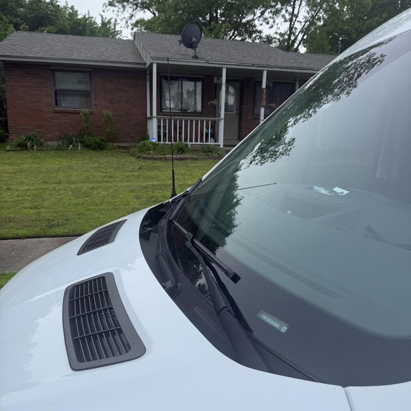 Front door lock of brick house with locksmith van nearby