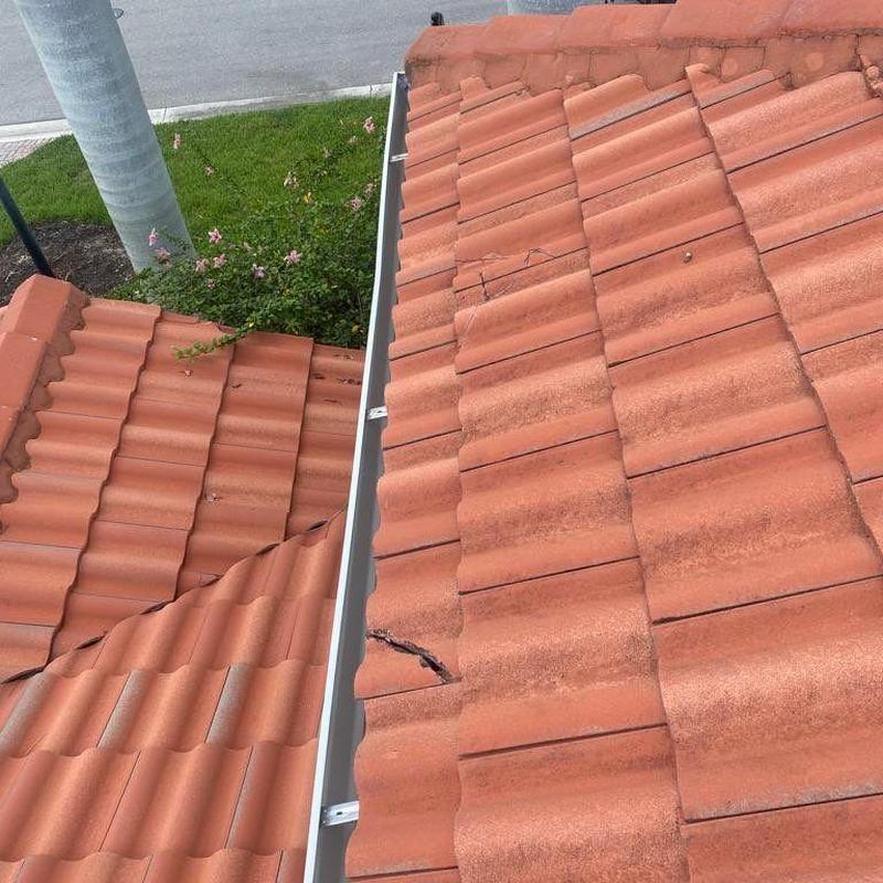 Tile roof with cracked and broken tiles near gutter