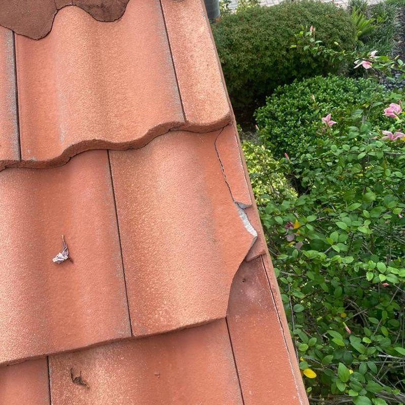 Tile roof with cracked and broken tiles at edge
