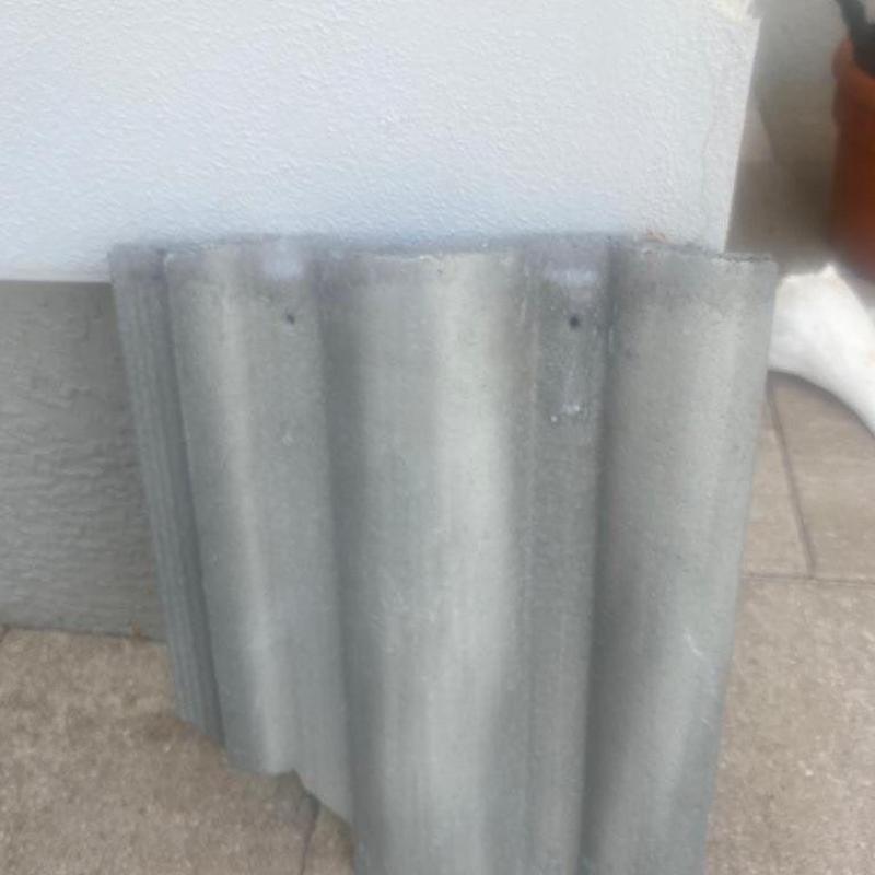 Concrete tile roof section leaning against wall