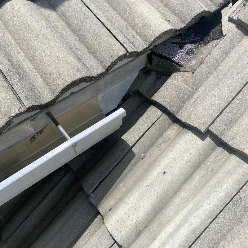 Concrete tile roof with repaired damaged tiles and flashing