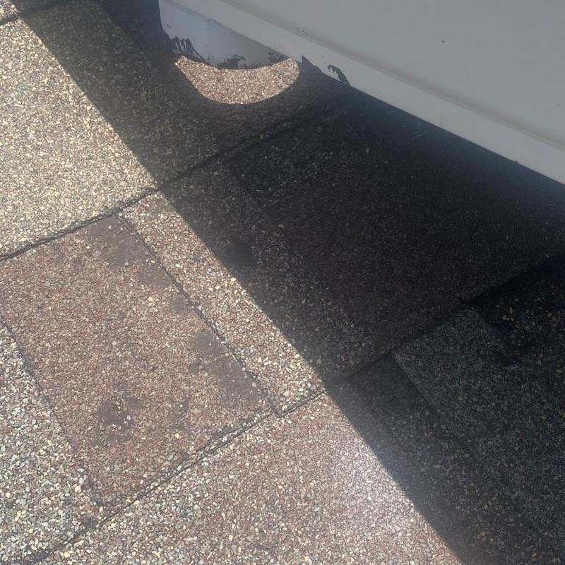 Shingle roof patch near roof vent on a residential home