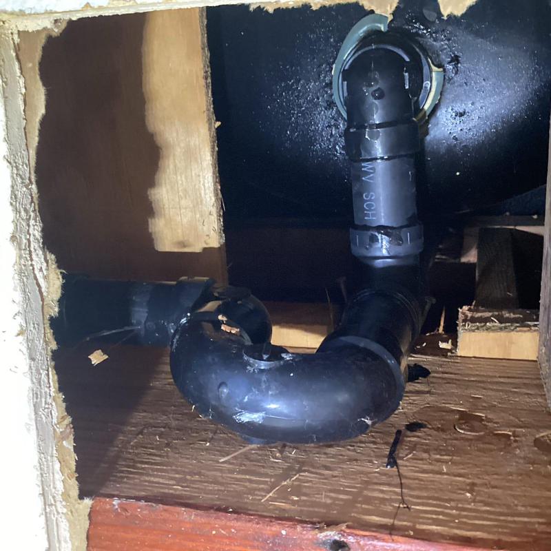Bathtub drain pipe with visible leak inspection opening