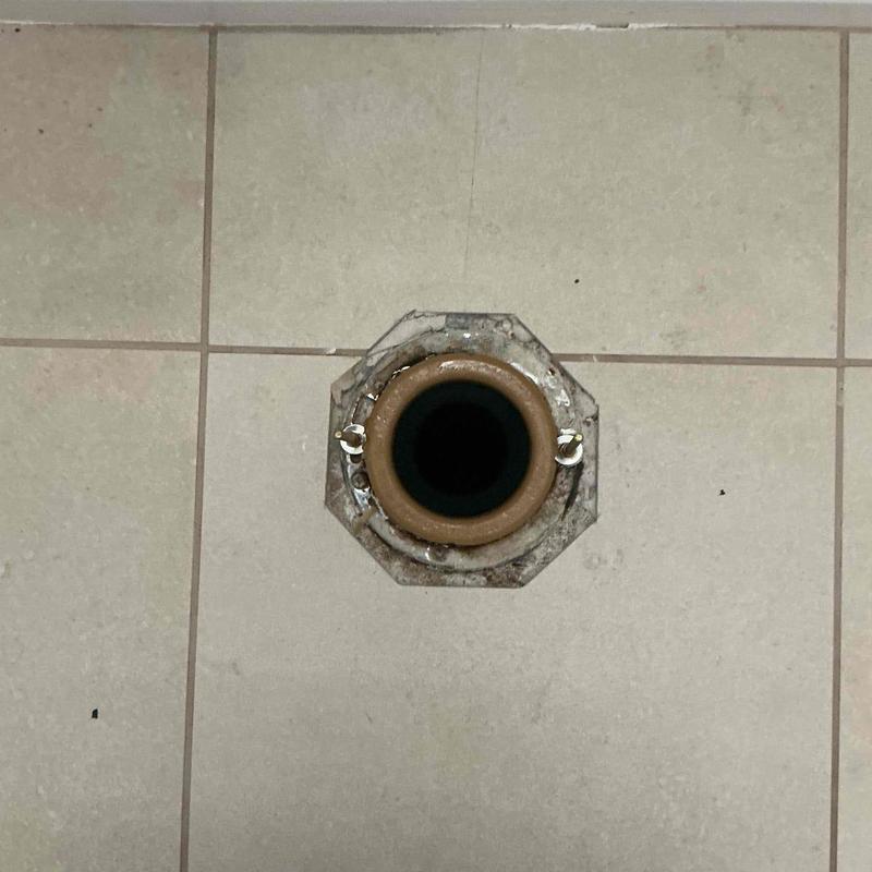 Toilet flange and wax ring on tiled floor