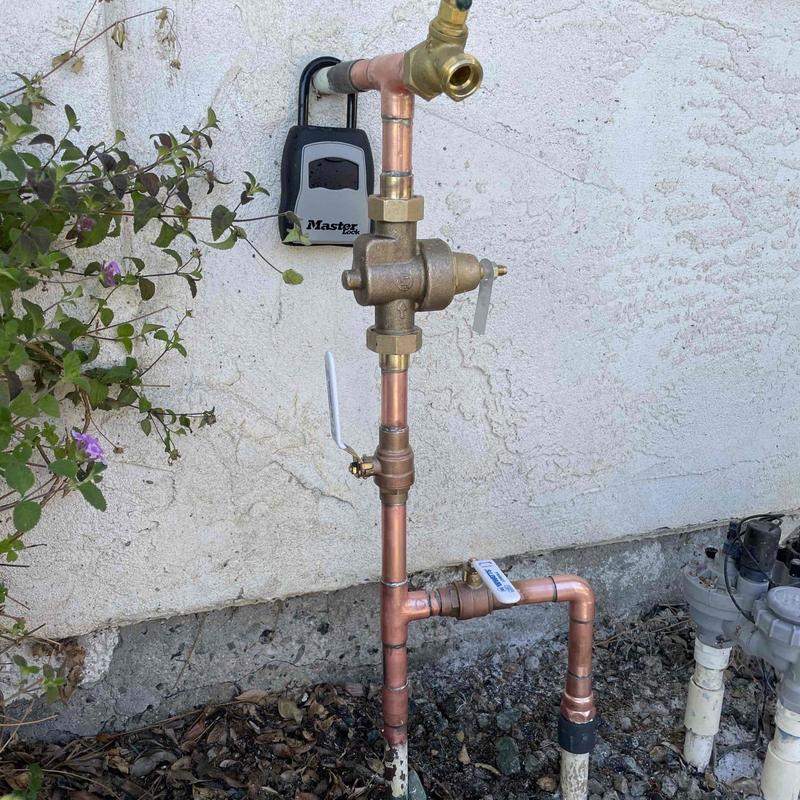 Pressure regulating valve with ball valves and hose bib