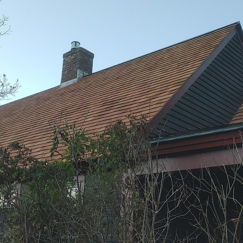 Cedar shake roof with chimney and foliage in Vermont