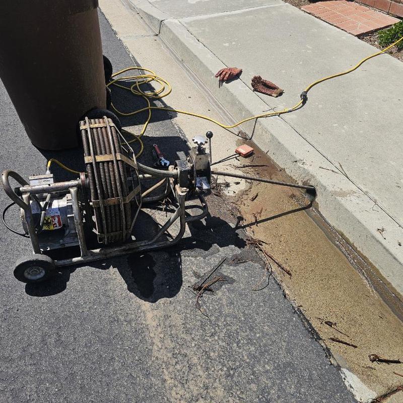Outdoor flange drain clog removal with rooting machine