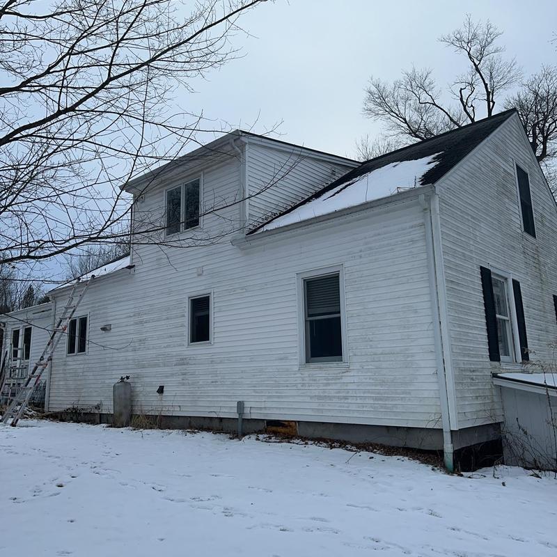 Vinyl siding on farmhouse exterior with snow cover