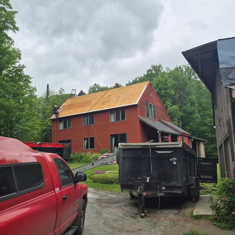 Roof decking installation on a red two-story house