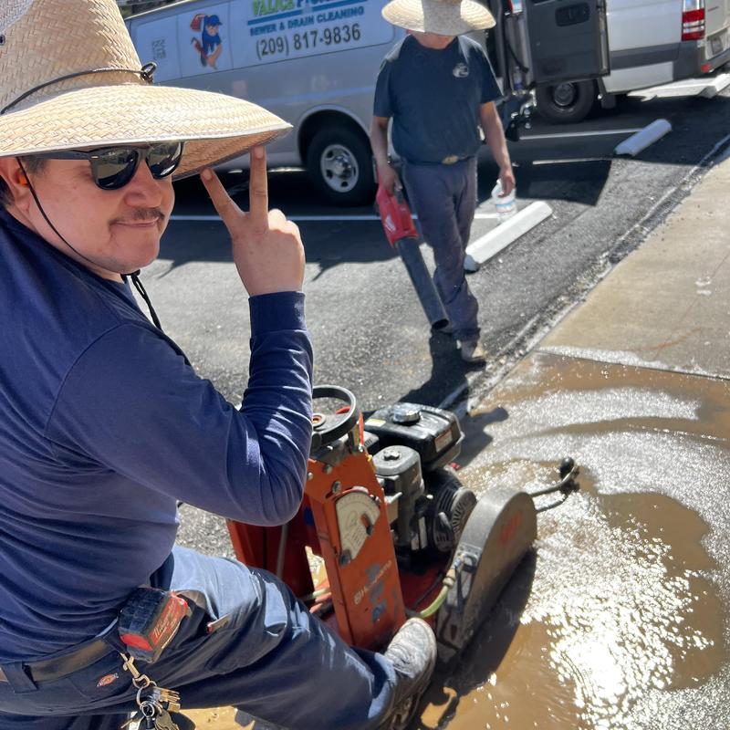 Concrete saw cutting asphalt near sewer repair site