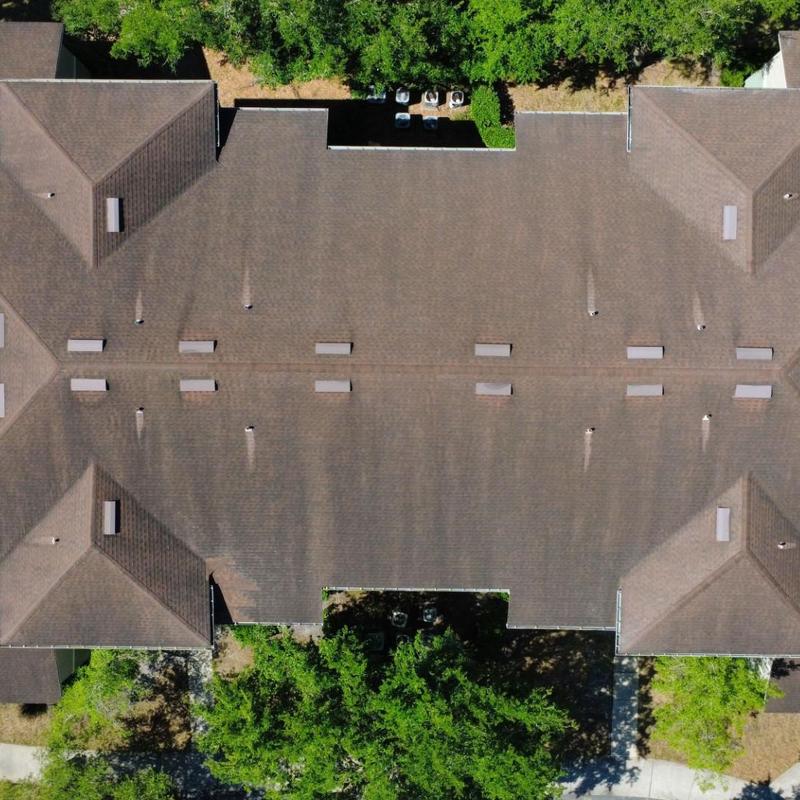 Apartment complex asphalt shingle roof with vents, aerial view