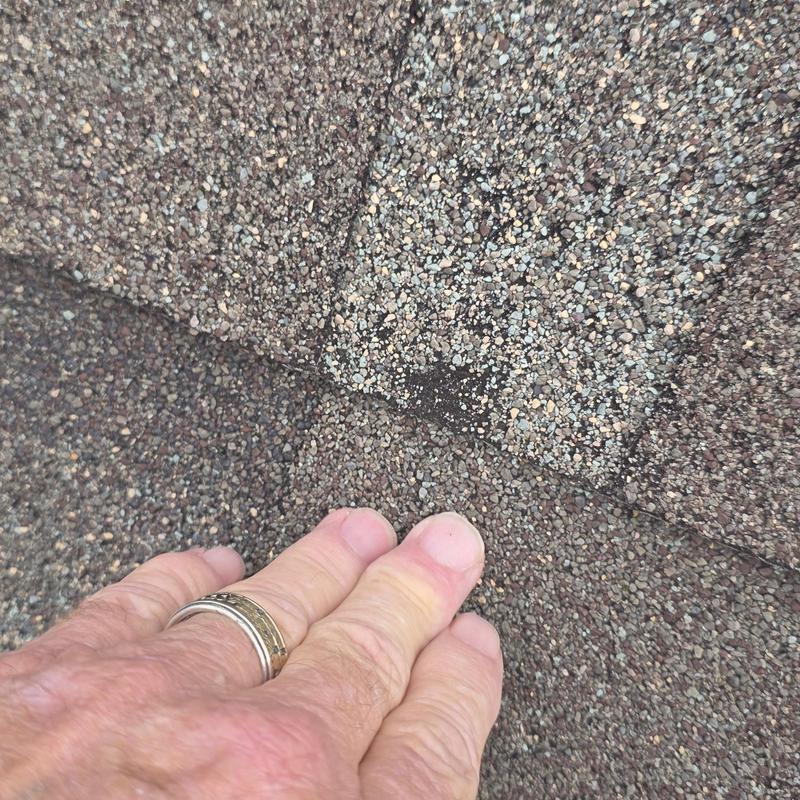 Asphalt shingle granule loss from hail damage close-up