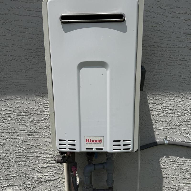 Tankless water heater unit mounted on exterior wall